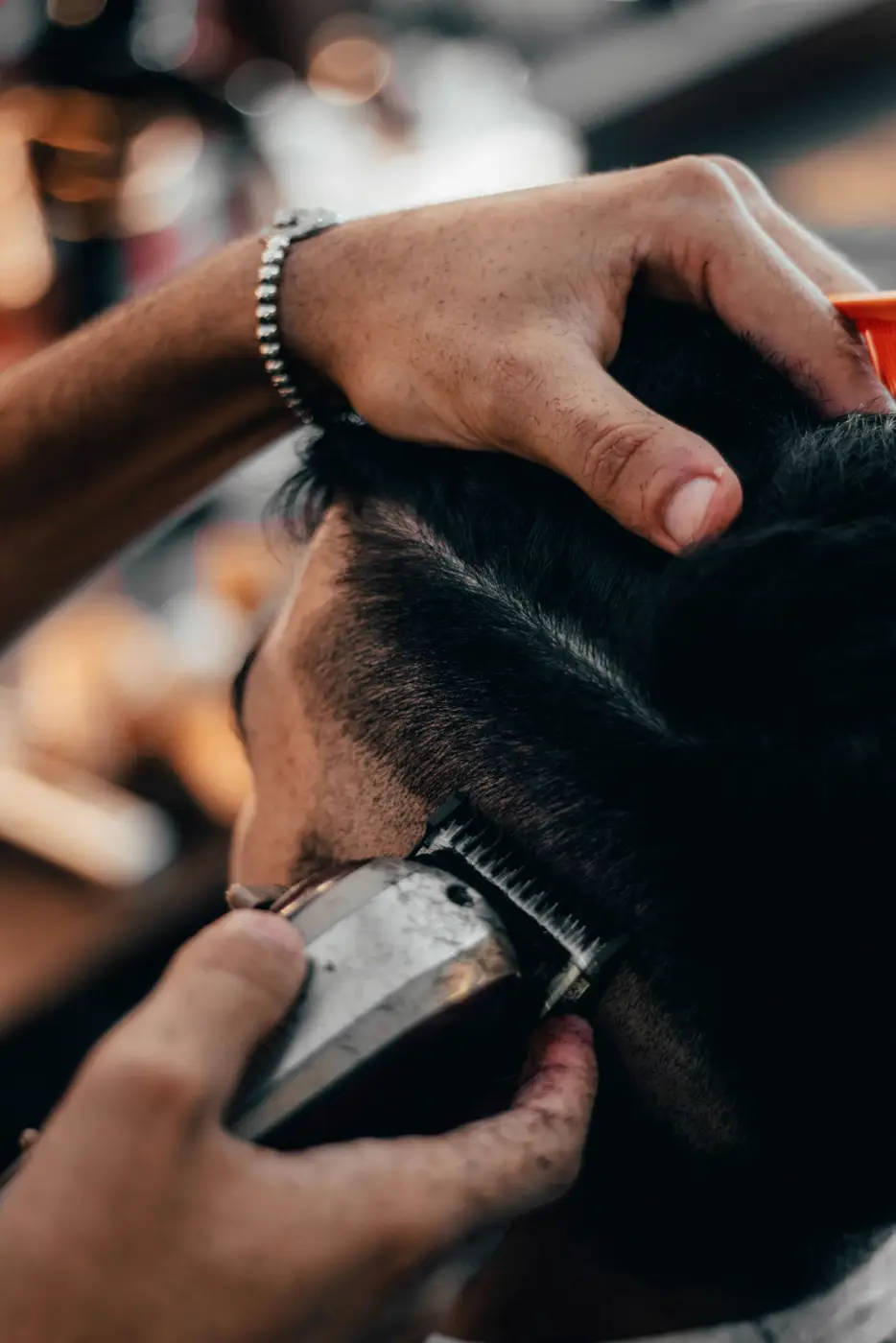 Plano cercano de una tijera recortando el cabello sobre la nuca