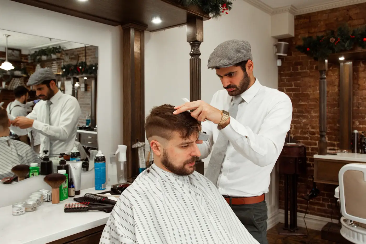 Barbero perfilando el corte de un cliente frente al espejo