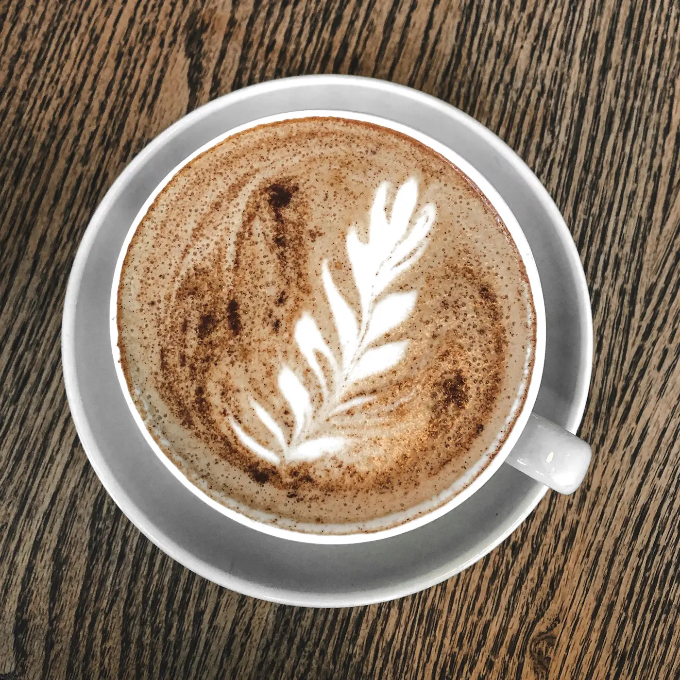 Café con leche con arte en la espuma visto desde arriba