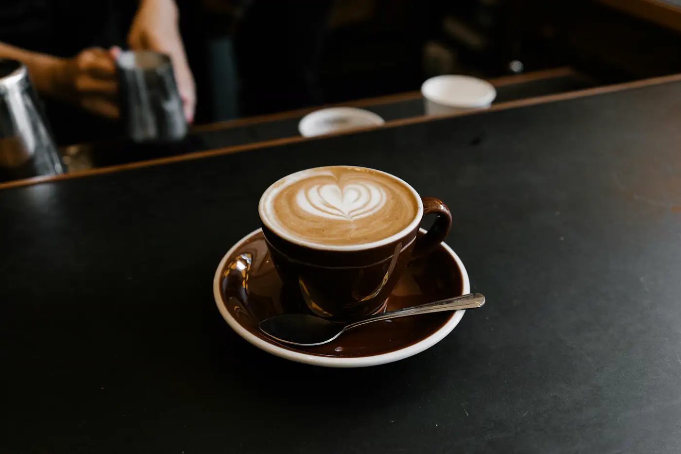 Taza pequeña de espresso servida sobre plato blanco